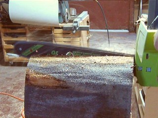  using the chainsaw to cut the wood into two halves